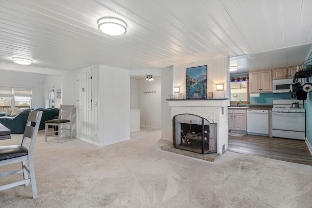 living room with sink, light hardwood / wood-style flooring, and a brick fireplace