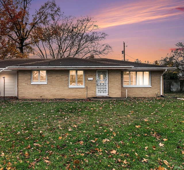 single story home featuring a yard and a garage