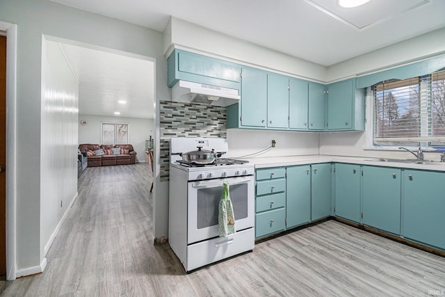 kitchen with tasteful backsplash, white gas range, sink, and light hardwood / wood-style floors