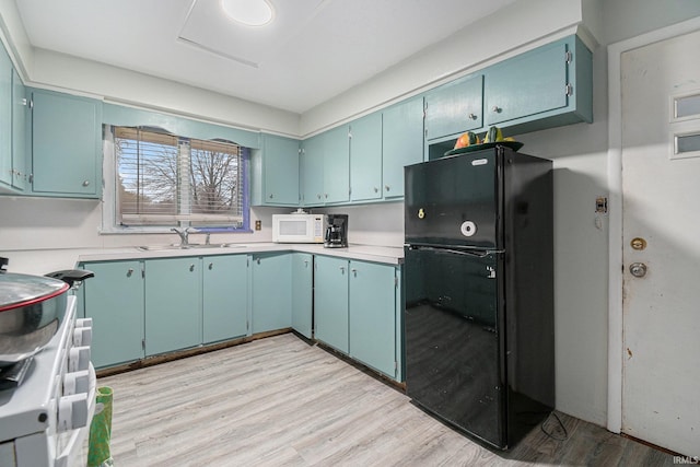 kitchen with white appliances, light hardwood / wood-style floors, and sink