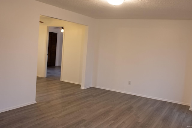 unfurnished room with a textured ceiling, dark hardwood / wood-style floors, and ceiling fan