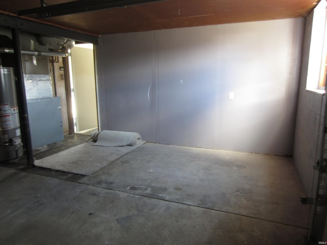 empty room with water heater and concrete flooring