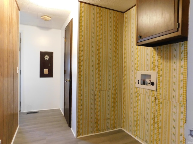 washroom with cabinets, washer hookup, and light hardwood / wood-style flooring