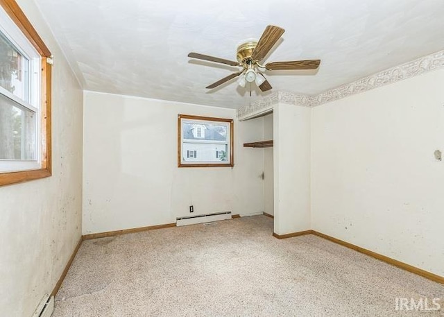 carpeted spare room with ceiling fan and baseboard heating