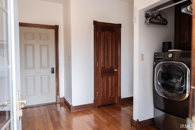 clothes washing area featuring hardwood / wood-style floors, cabinets, and washer / clothes dryer