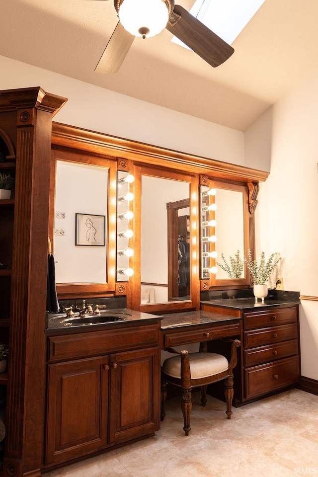 bar featuring dark brown cabinetry, ceiling fan, and sink