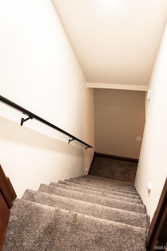 stairway with carpet flooring and vaulted ceiling