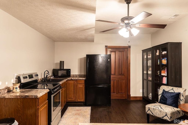 kitchen with black appliances, sink, ceiling fan, a textured ceiling, and dark hardwood / wood-style flooring