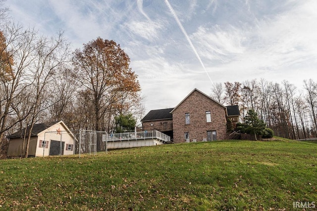 view of yard featuring a deck and an outdoor structure