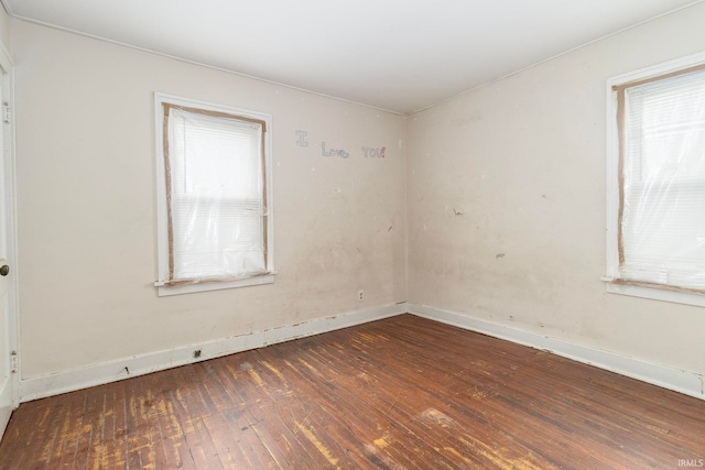 empty room with a healthy amount of sunlight and dark hardwood / wood-style floors