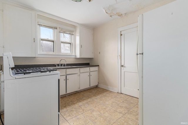 kitchen featuring white cabinetry, light tile patterned flooring, white gas range, and sink