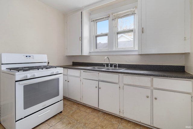 kitchen featuring white cabinets, gas range gas stove, and sink