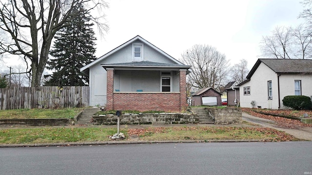 bungalow with a garage and an outbuilding