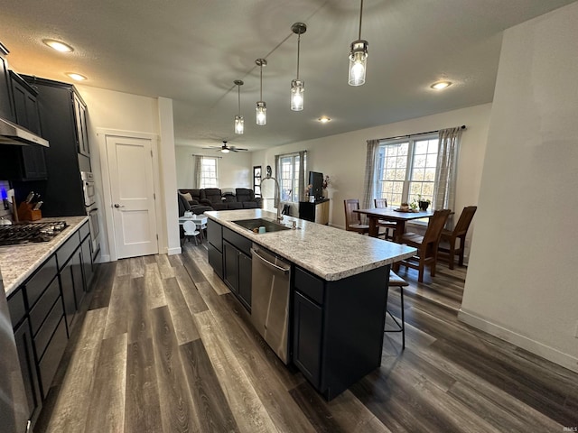 kitchen featuring pendant lighting, sink, dark hardwood / wood-style floors, an island with sink, and stainless steel appliances