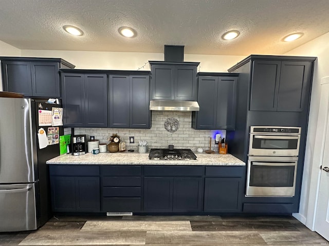 kitchen featuring dark hardwood / wood-style flooring, a textured ceiling, appliances with stainless steel finishes, and tasteful backsplash