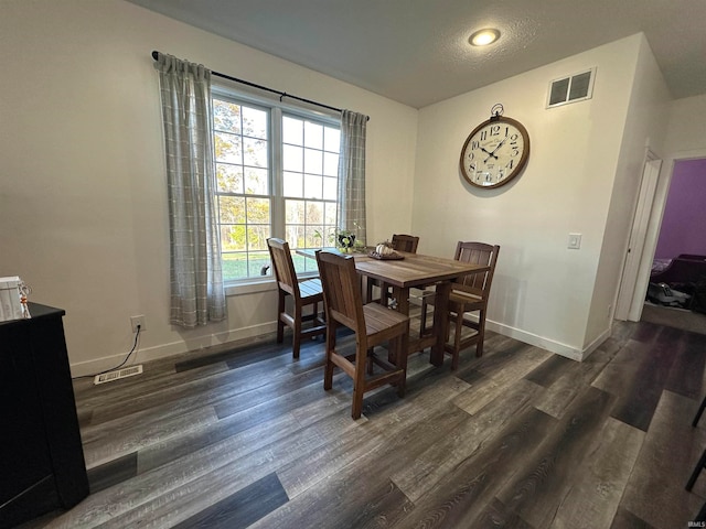 dining space featuring a textured ceiling and dark hardwood / wood-style floors