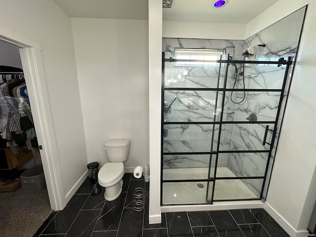 bathroom with a tile shower and toilet