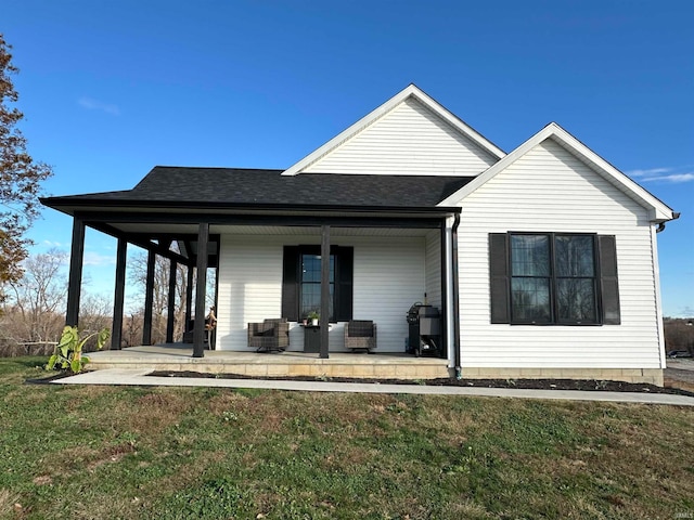 rear view of house with a lawn and covered porch