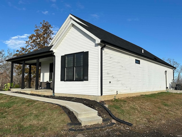 view of home's exterior featuring a lawn and covered porch