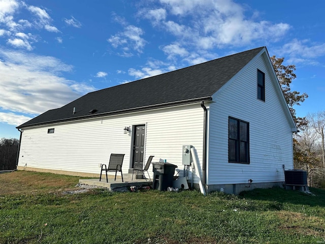 rear view of property with a lawn and central air condition unit