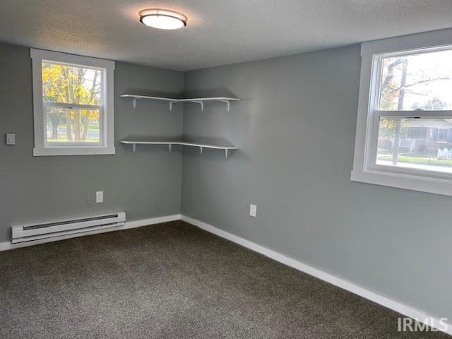 interior space featuring carpet and a baseboard heating unit