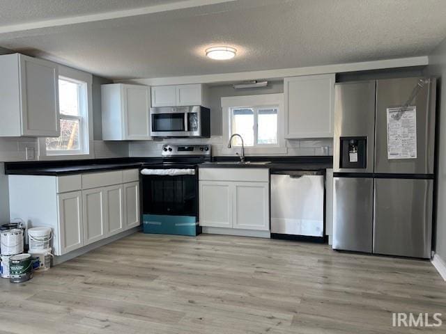 kitchen with white cabinets, stainless steel appliances, plenty of natural light, and sink