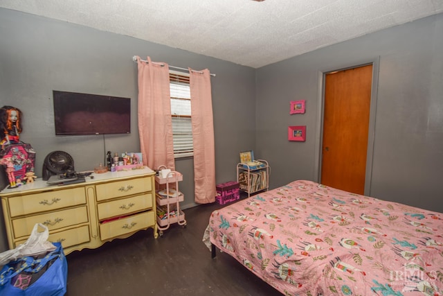 bedroom with a textured ceiling and dark hardwood / wood-style flooring