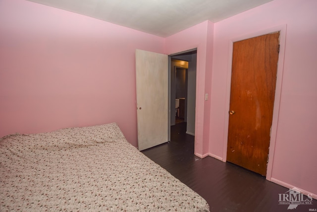 bedroom with a closet and dark hardwood / wood-style floors