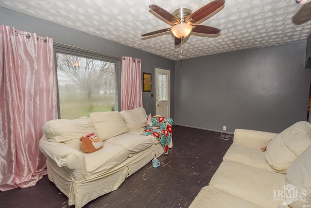 living room featuring ceiling fan and a textured ceiling