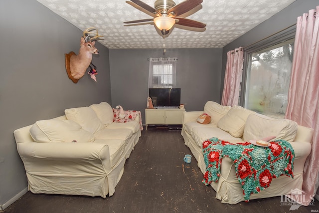 living room featuring a textured ceiling, dark hardwood / wood-style flooring, and ceiling fan