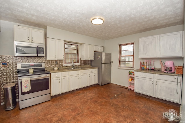 kitchen featuring white cabinetry, sink, a textured ceiling, and appliances with stainless steel finishes