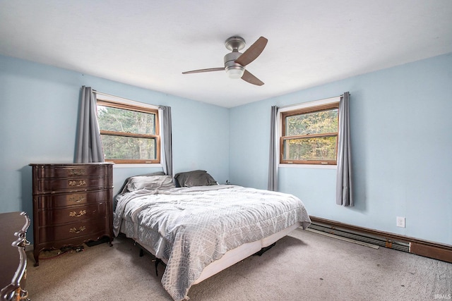 bedroom with ceiling fan, light colored carpet, and multiple windows