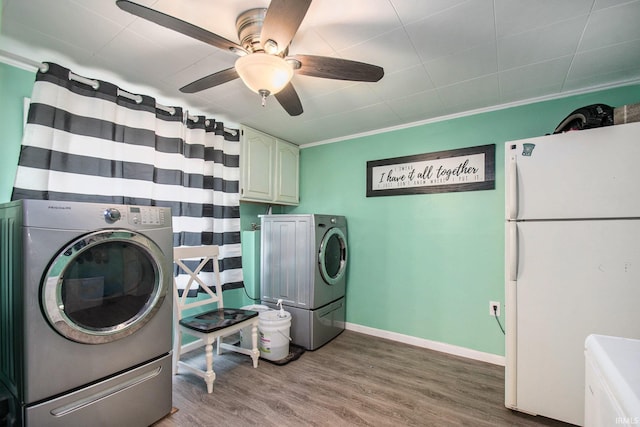 washroom with cabinets, ornamental molding, ceiling fan, wood-type flooring, and independent washer and dryer