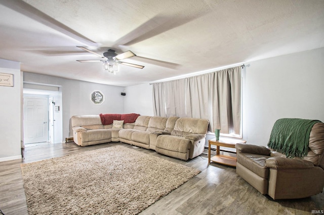 living room featuring a textured ceiling, hardwood / wood-style flooring, and ceiling fan