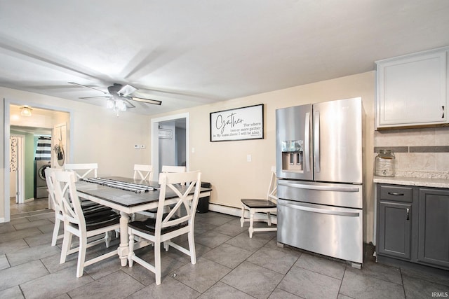 tiled dining room with washer / dryer and ceiling fan