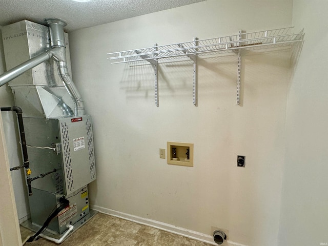 clothes washing area with hookup for an electric dryer, a textured ceiling, and hookup for a washing machine