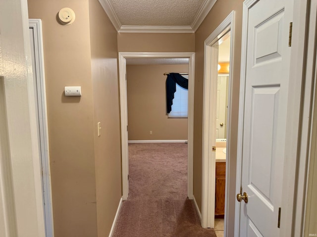 hallway featuring ornamental molding, a textured ceiling, and light carpet