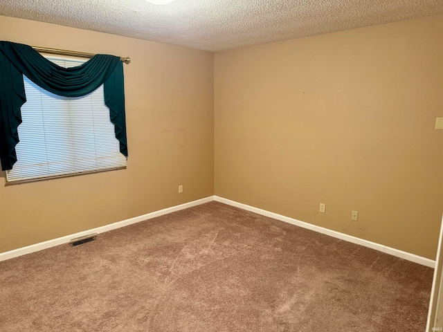 carpeted empty room featuring a textured ceiling