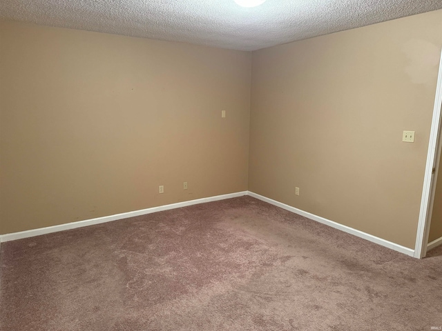 carpeted empty room featuring a textured ceiling