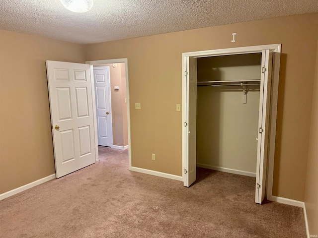 unfurnished bedroom with light carpet, a textured ceiling, and a closet