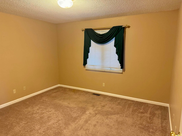 carpeted empty room with a textured ceiling