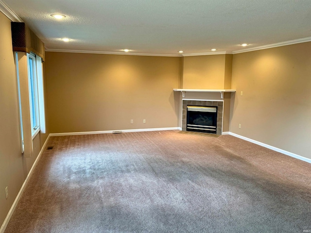 unfurnished living room with a tile fireplace, crown molding, carpet floors, and a textured ceiling