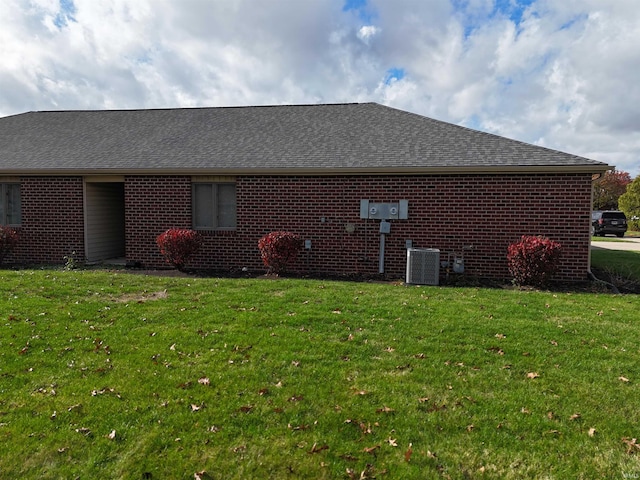 view of side of property featuring central air condition unit and a yard