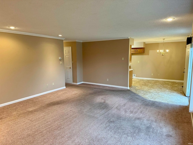 unfurnished room with carpet, ornamental molding, a textured ceiling, and a notable chandelier