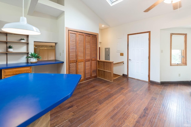 interior space with electric panel, ceiling fan, dark hardwood / wood-style flooring, and high vaulted ceiling