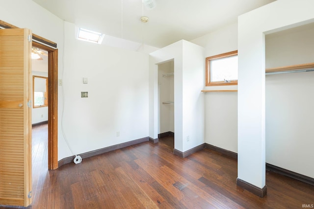 unfurnished bedroom with a closet and dark wood-type flooring