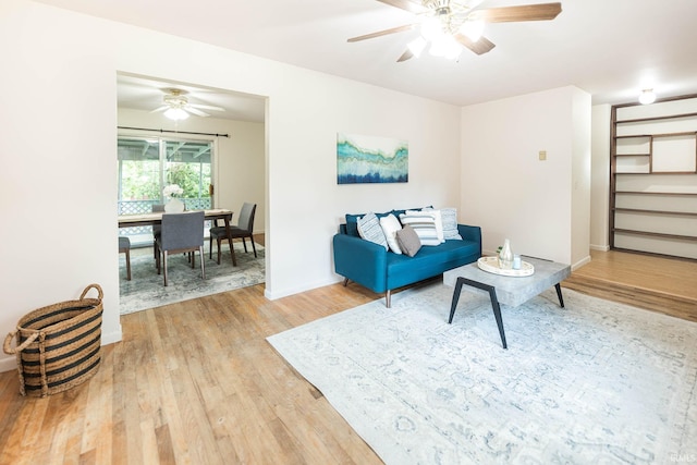 living room with ceiling fan and light hardwood / wood-style flooring