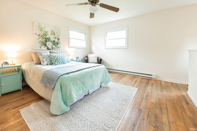 bedroom with ceiling fan, hardwood / wood-style floors, and a baseboard radiator