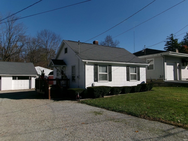 view of property exterior featuring a garage, an outdoor structure, and a lawn