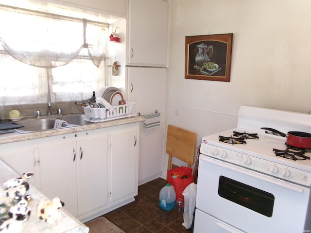 kitchen with white cabinets, sink, and white gas range oven